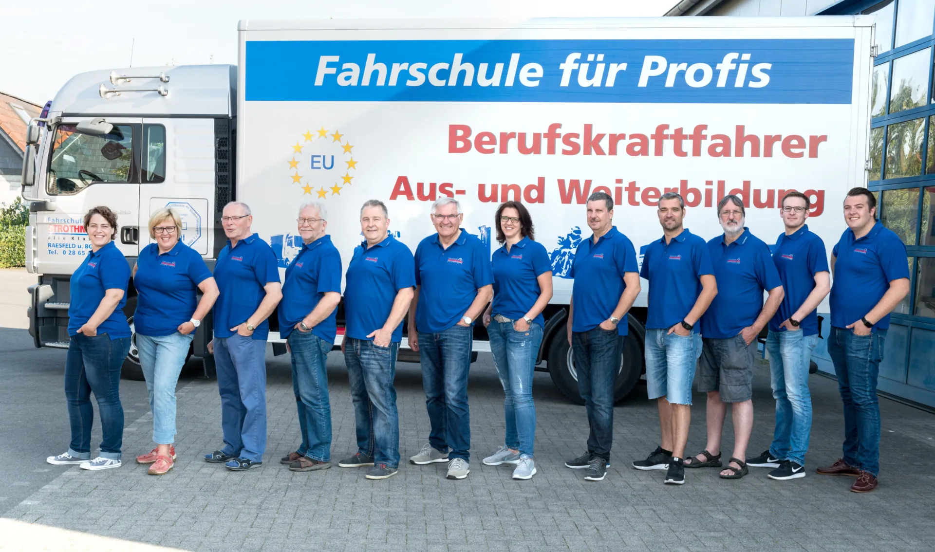 Das Team der Fahrschule Strothmann vor den Ausbildungs-LKW